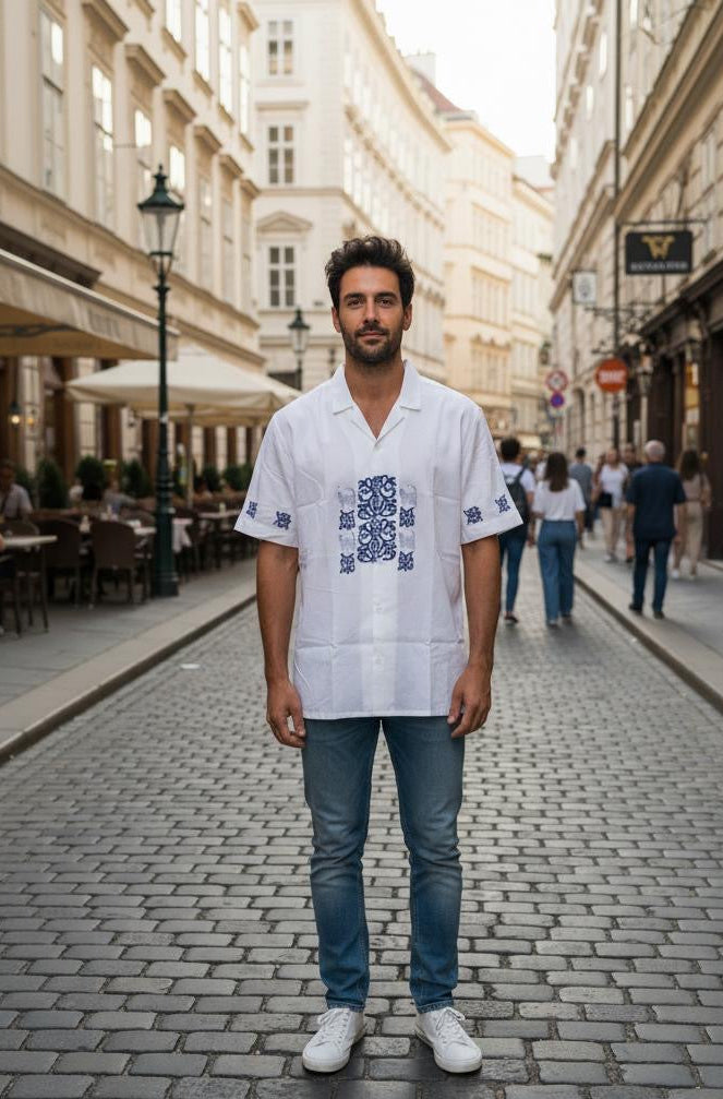 Male model wearing Belleoria navy handblock printed shirt with navy floral and cat motifs, standing in a Rome city background.