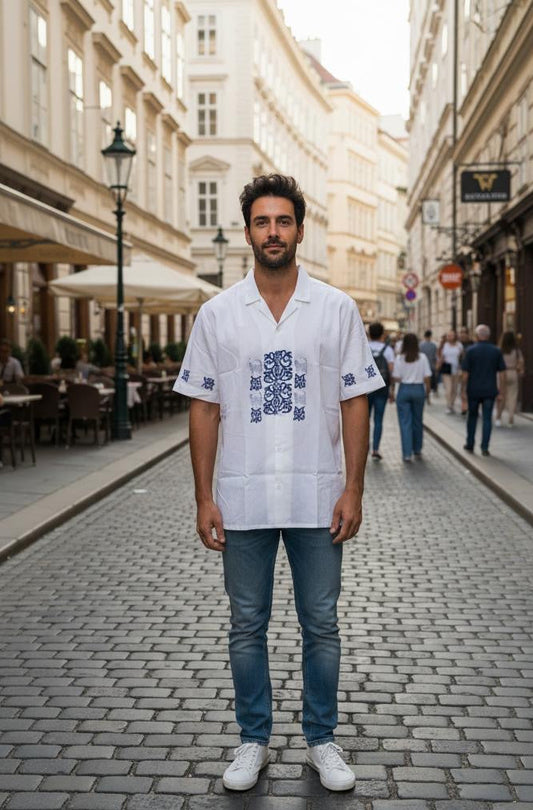 Male model wearing Belleoria navy handblock printed shirt with navy floral and cat motifs, standing in a Rome city background.
