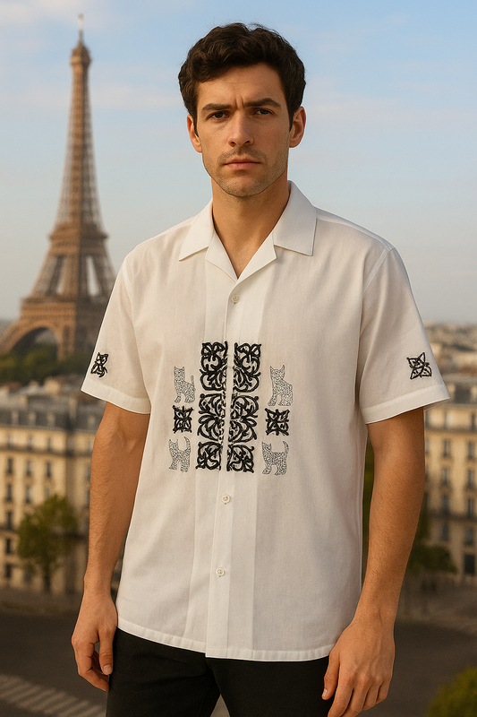 Man wearing a white shirt with black patterns in front of the Eiffel Tower.