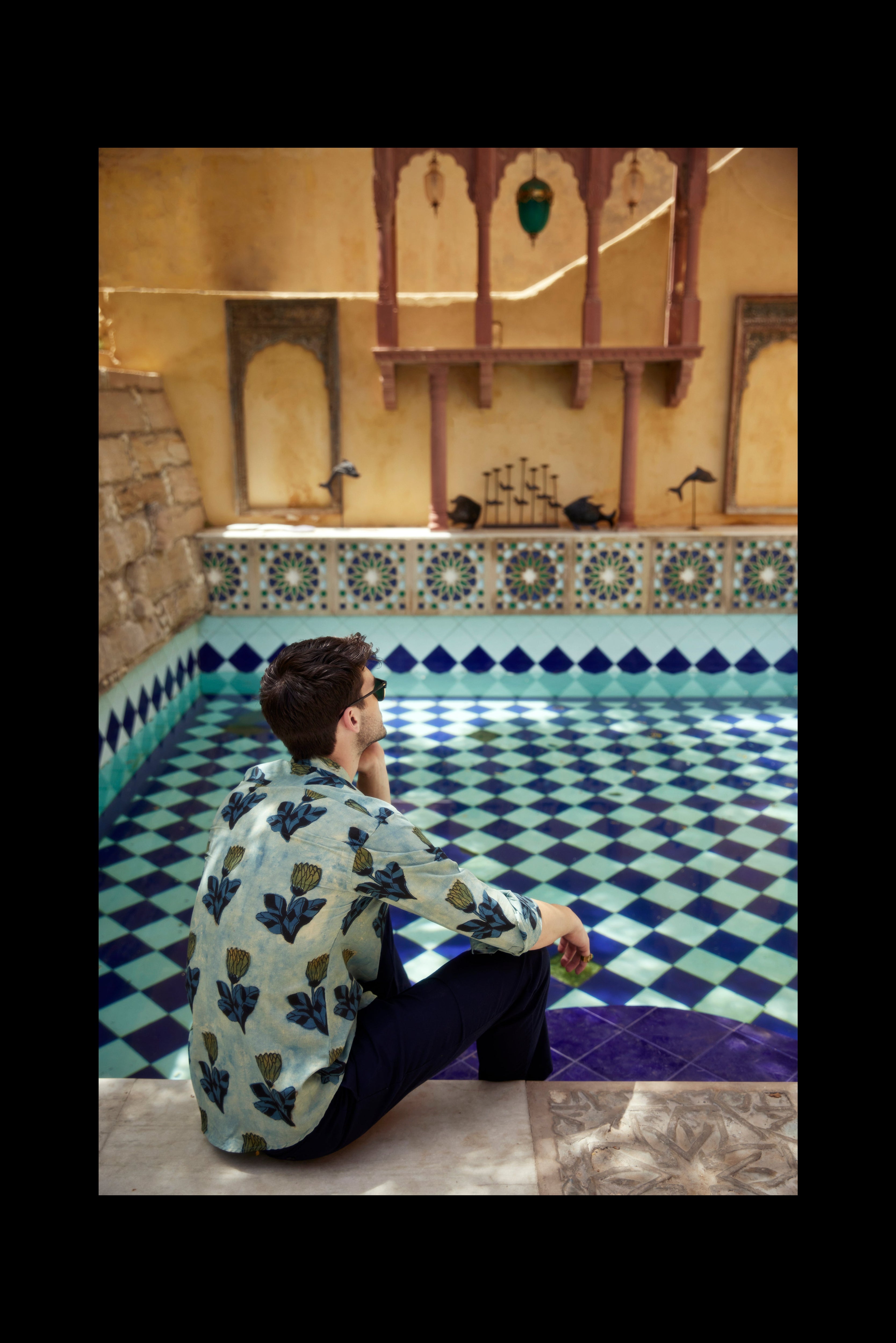 man wearing a hand blocked print shirt from jaipur near a pool